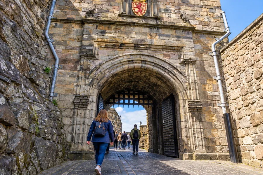 A visitor carrying a small daypack through Edinburgh Castle’s Portcullis Gate